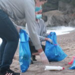 Collecting rubbish off a beach. Plastic containers. Activists Working Together. Making a Difference.Video,4k resolution.
