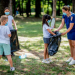 School children picking up garbage together while cleaning public park